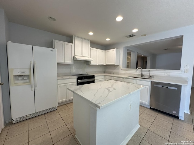 kitchen featuring white refrigerator with ice dispenser, stainless steel dishwasher, black electric range, under cabinet range hood, and a sink