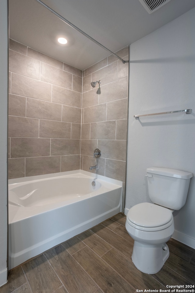 full bathroom featuring baseboards, visible vents, toilet, shower / bathtub combination, and wood finish floors