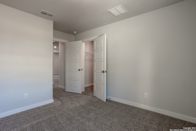 unfurnished bedroom featuring carpet flooring, visible vents, and baseboards