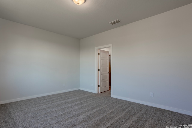 spare room with carpet, visible vents, and baseboards