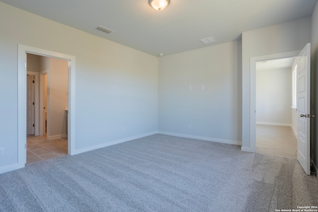 unfurnished bedroom featuring carpet floors, visible vents, and baseboards