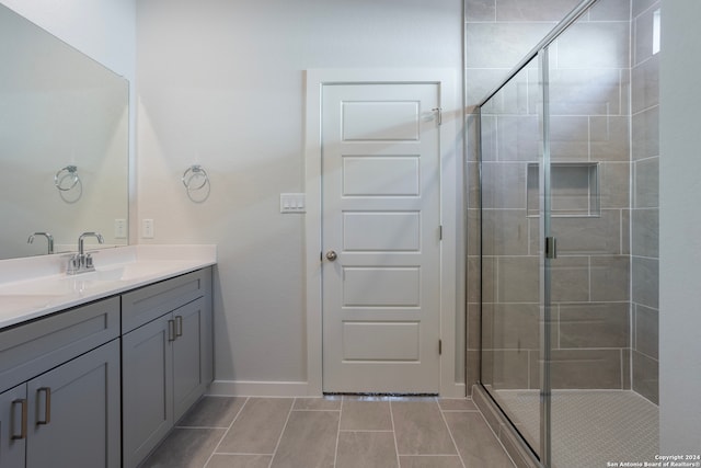 full bath with a stall shower, vanity, and baseboards