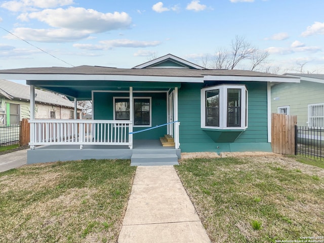 bungalow-style house with fence, a porch, and a front yard