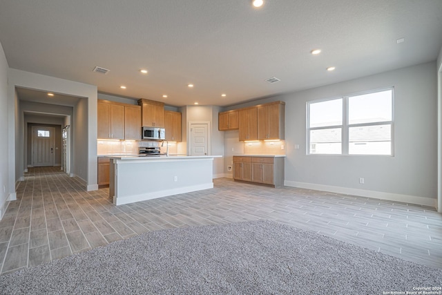 kitchen featuring recessed lighting, stainless steel appliances, wood finish floors, visible vents, and light countertops