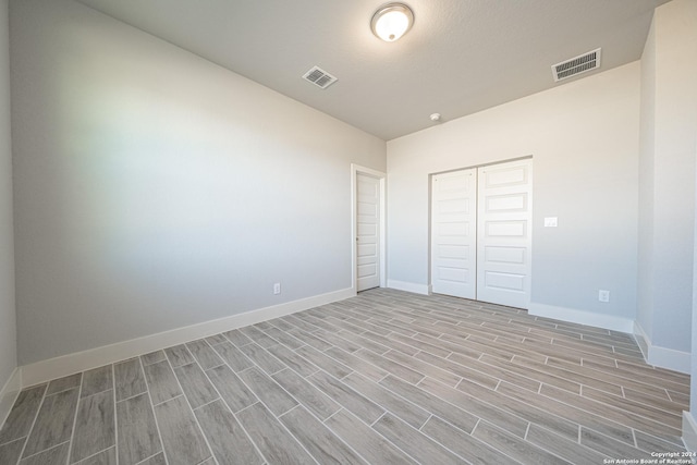 unfurnished bedroom with a closet, visible vents, and baseboards