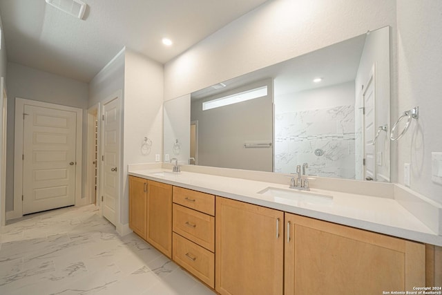 full bathroom with marble finish floor, visible vents, a sink, and double vanity