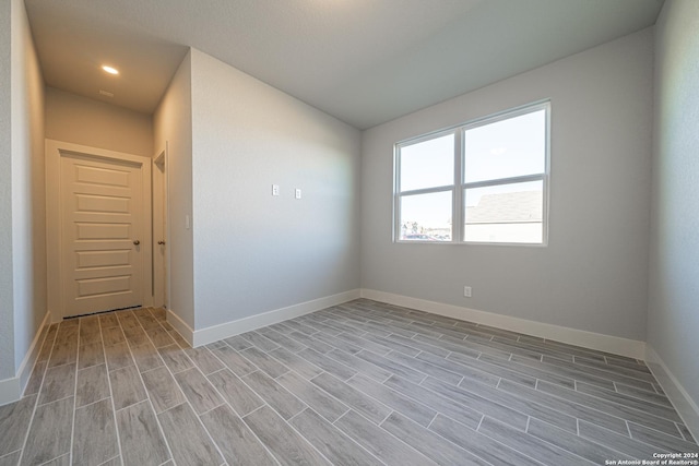 empty room featuring baseboards and wood finish floors