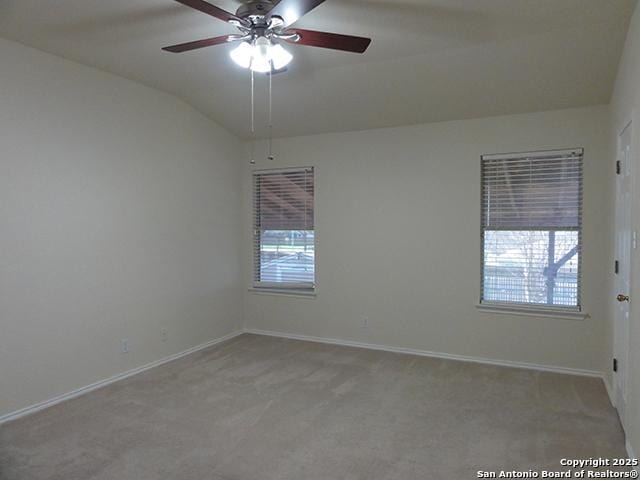 unfurnished room with lofted ceiling, a ceiling fan, baseboards, and carpet flooring