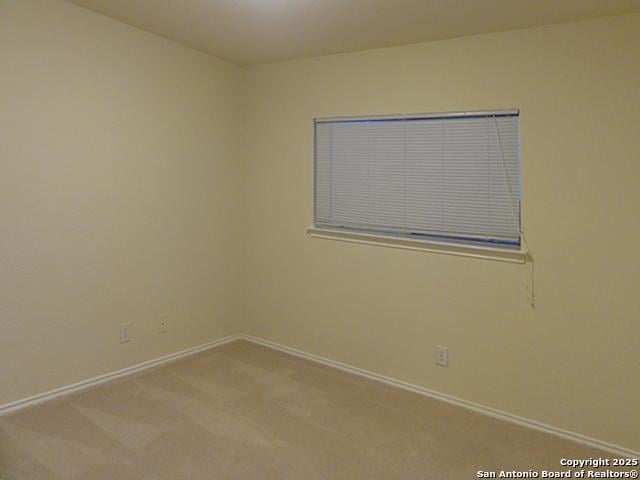 spare room with baseboards and carpet flooring