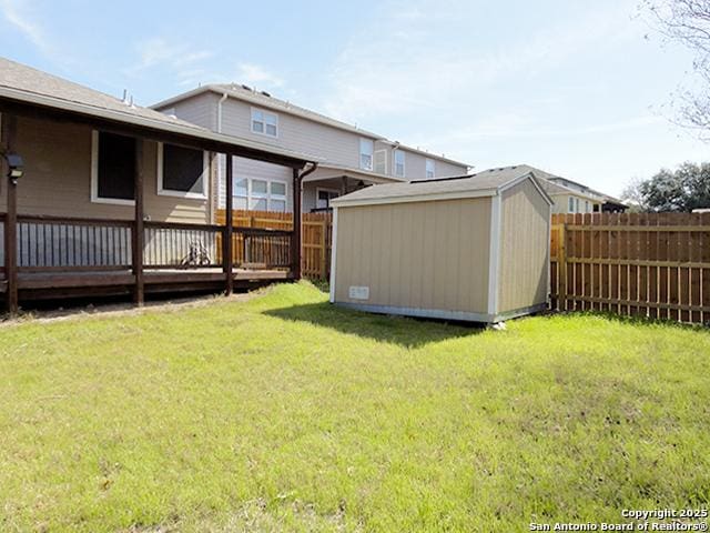 view of yard with an outbuilding, a fenced backyard, and a storage unit