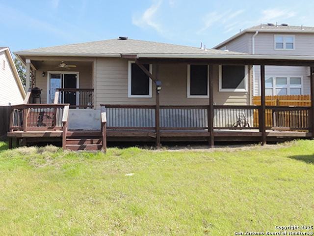 back of property featuring a ceiling fan, a lawn, and a wooden deck