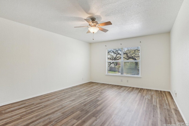 empty room featuring a ceiling fan, a textured ceiling, baseboards, and wood finished floors