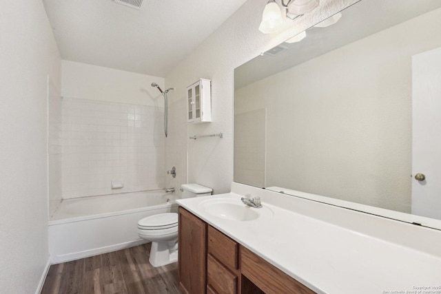 full bathroom with bathtub / shower combination, toilet, wood finished floors, visible vents, and vanity