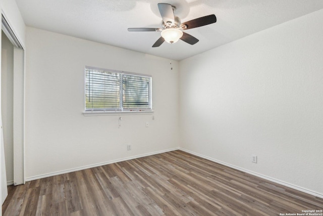 unfurnished bedroom featuring ceiling fan, a closet, wood finished floors, and baseboards