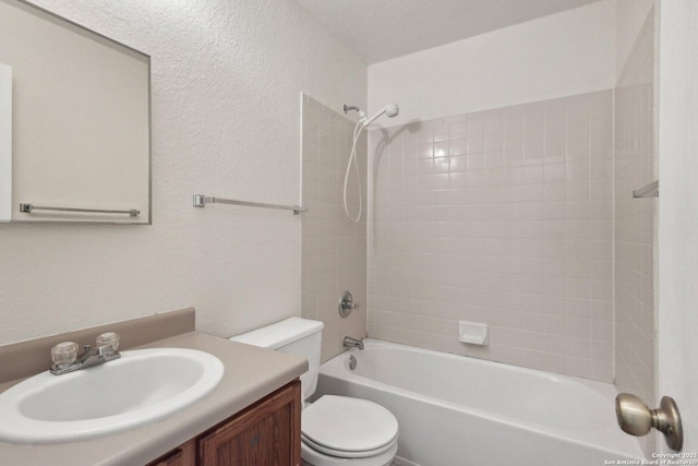 bathroom featuring toilet, a textured wall, shower / washtub combination, and vanity