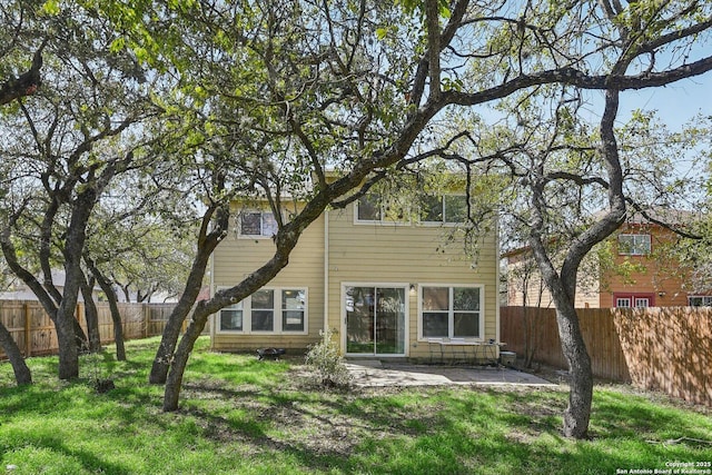 rear view of property with a lawn, a patio area, and a fenced backyard