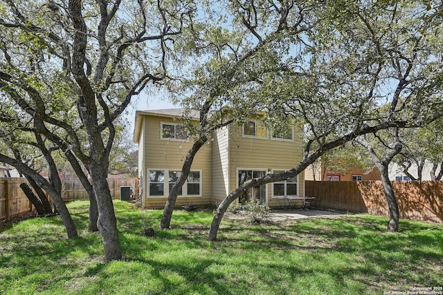 back of house featuring a fenced backyard, central AC, and a lawn