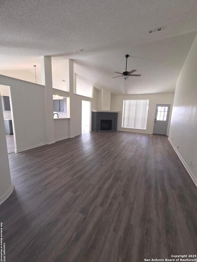 unfurnished living room featuring lofted ceiling, visible vents, a fireplace, and ceiling fan