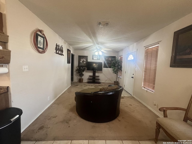 corridor featuring light colored carpet, visible vents, a textured ceiling, and baseboards