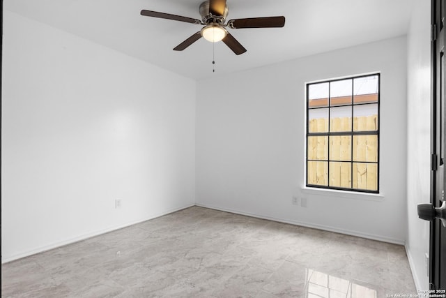 empty room featuring a ceiling fan and baseboards
