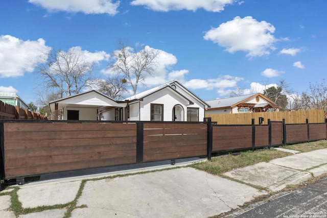 ranch-style home with a fenced front yard and a gate