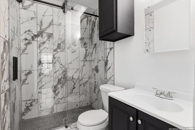 full bath with toilet, a marble finish shower, and vanity