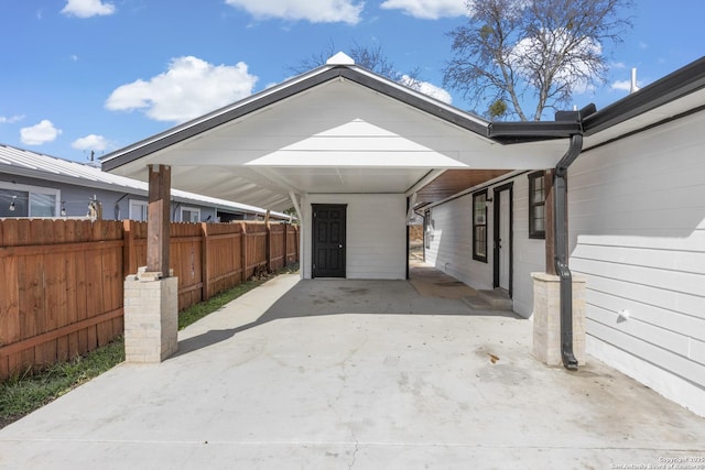 view of patio featuring a carport, fence, and concrete driveway