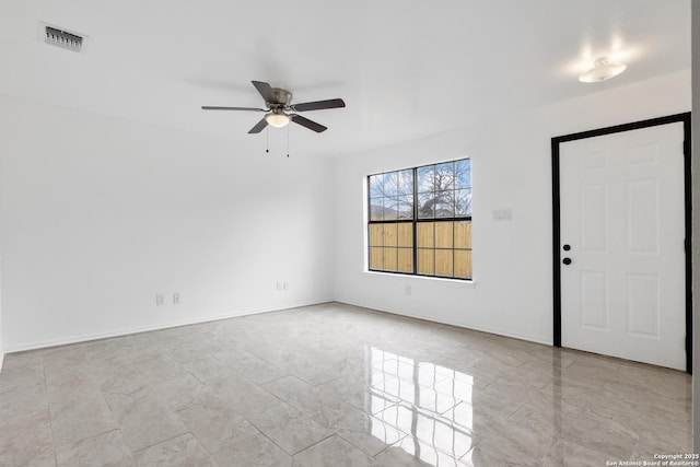 empty room featuring marble finish floor, visible vents, ceiling fan, and baseboards