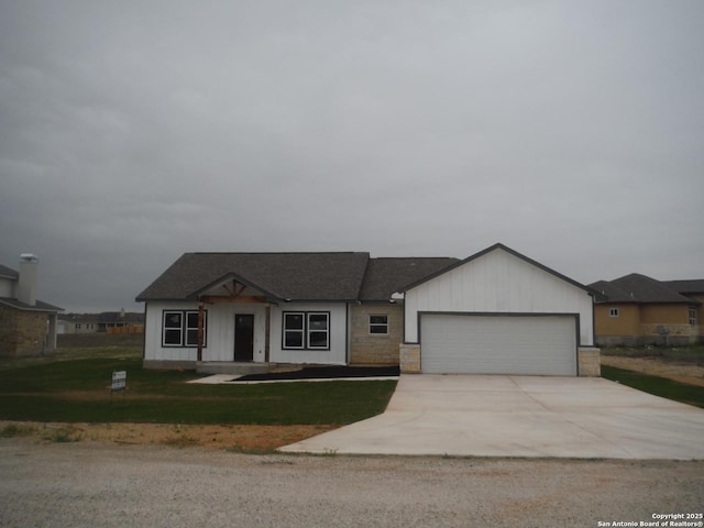 view of front of property with a front yard, an attached garage, and driveway