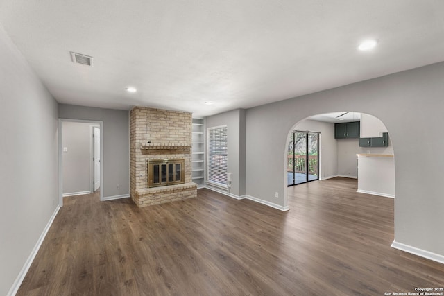 unfurnished living room featuring visible vents, a fireplace, baseboards, and dark wood-type flooring