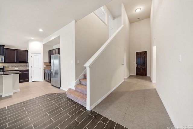 stairs with recessed lighting, visible vents, baseboards, and tile patterned floors