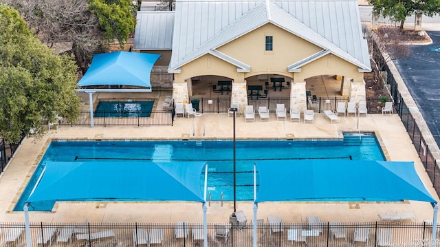 community pool with a patio and fence