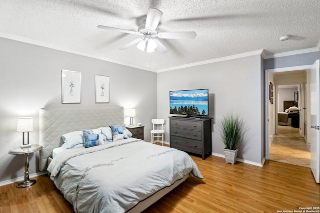 bedroom with light wood-type flooring, crown molding, baseboards, and a textured ceiling