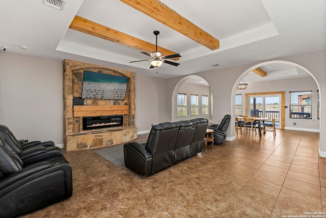 living room featuring visible vents, plenty of natural light, a fireplace, and a tray ceiling