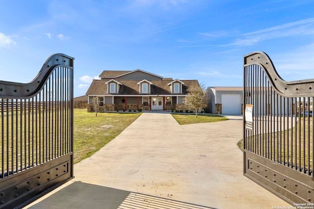 view of gate with an outbuilding, a lawn, and fence