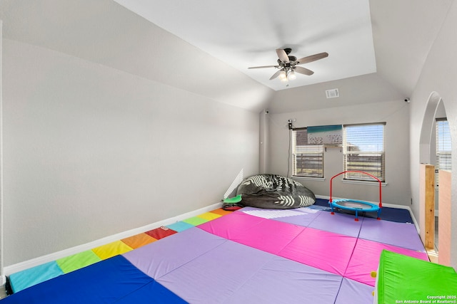 exercise room with visible vents, baseboards, ceiling fan, and vaulted ceiling