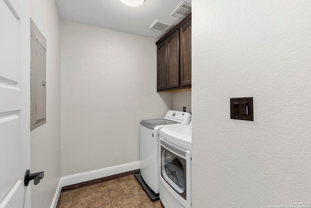 clothes washing area with tile patterned flooring, visible vents, baseboards, washer and dryer, and cabinet space