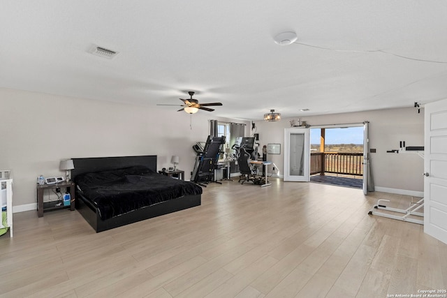 bedroom with access to exterior, visible vents, light wood-type flooring, and baseboards