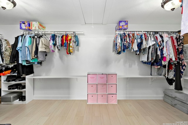 spacious closet featuring attic access and wood finished floors