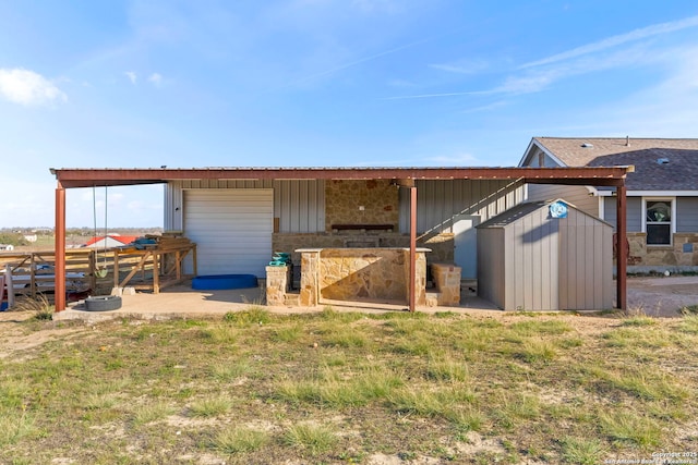 rear view of property featuring a garage and an outdoor structure