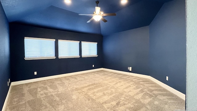 carpeted empty room with ceiling fan, baseboards, and vaulted ceiling