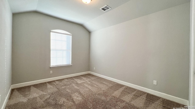 unfurnished room with lofted ceiling, baseboards, visible vents, and light colored carpet