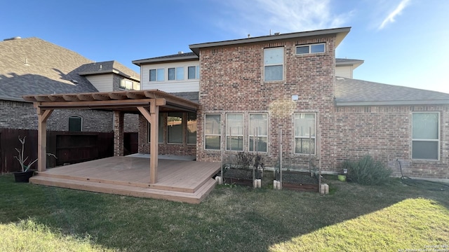 back of house with brick siding, a deck, and a yard