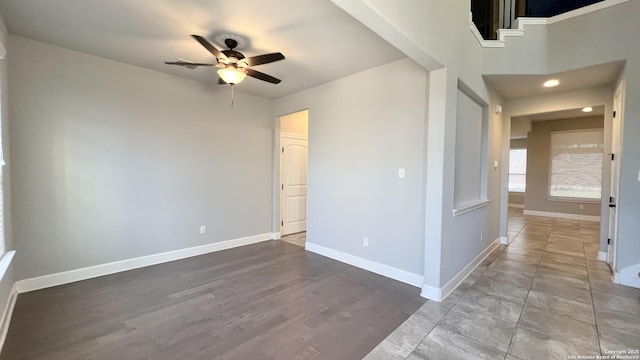 spare room featuring ceiling fan, wood finished floors, and baseboards