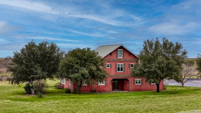 view of front facade with board and batten siding and a front yard