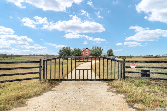 view of gate featuring a rural view and fence