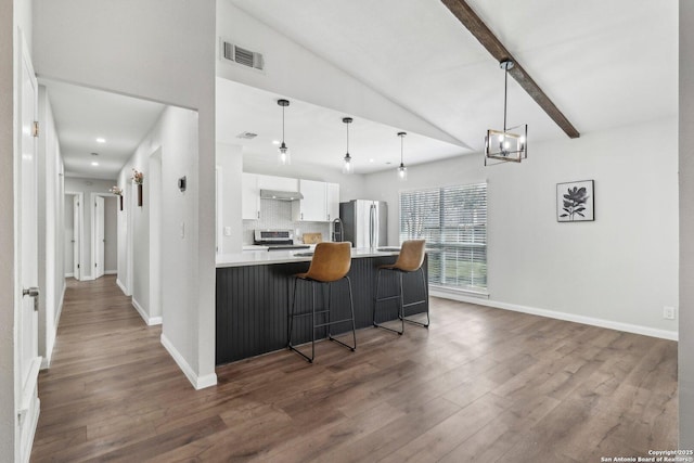 kitchen featuring a breakfast bar, visible vents, backsplash, appliances with stainless steel finishes, and white cabinets