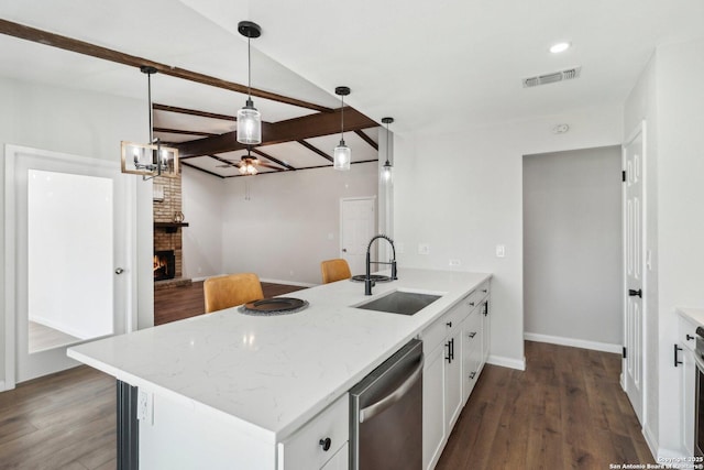 kitchen with a peninsula, a fireplace, a sink, visible vents, and dishwasher