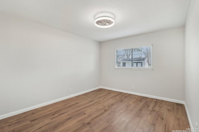 empty room with baseboards and wood finished floors