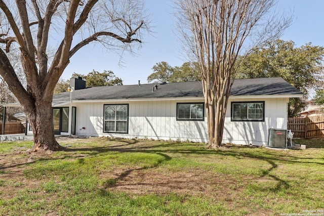 back of property featuring a yard, a chimney, fence, and central air condition unit